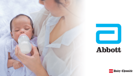 Woman feeding her child with a milk bottle beside the Abbott logo