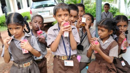 School children drinking milk from cartons, promoting healthy nutrition.