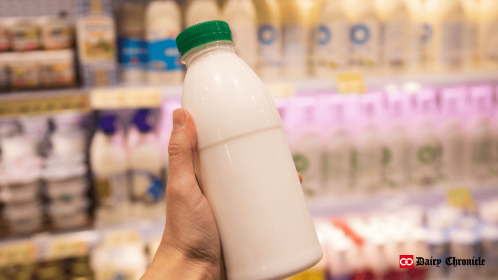 A hand holding a milk bottle, symbolizing the celebration of June Dairy Month and the contributions of dairy farmers.