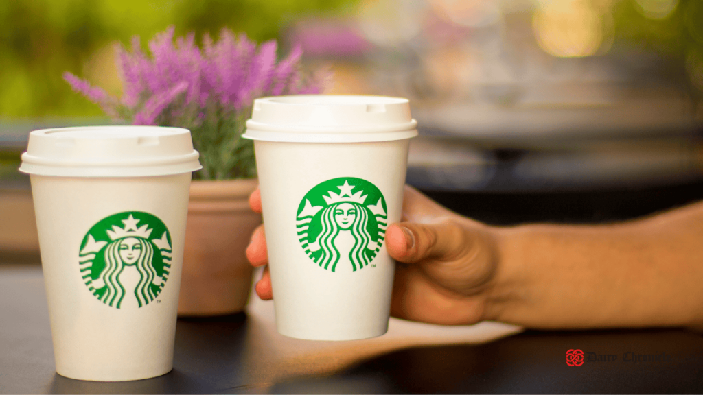 Two Starbucks coffee cups, highlighting the availability of plant-based milk options and dairy-containing ingredients.