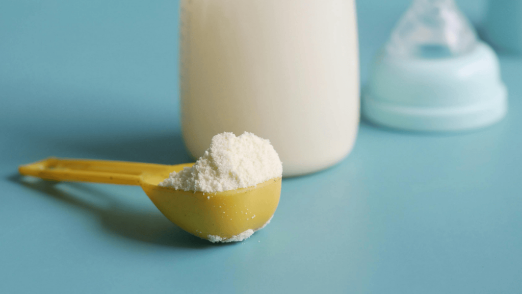 Scoop of powdered infant formula isolated on white background.