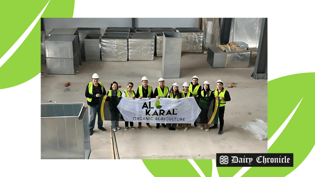 A group of people standing in a factory holding a banner of AL KARAL Organic Agriculture brand, representing the company's expansion plans