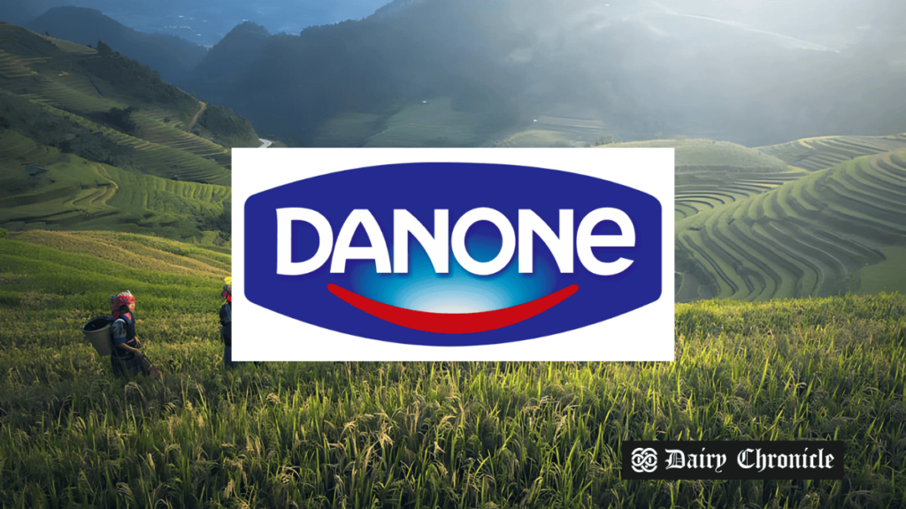 Field in the background with the Danone logo in the front, symbolizing the collaboration between Danone Thailand and Bangkok authorities to tackle child anemia.