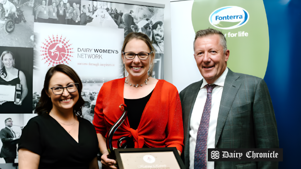 A woman receiving the Fonterra Dairy Woman of the Year award, surrounded by judges at the ceremony, showcasing her achievement in the dairy industry.